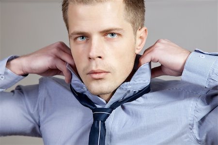 simsearch:400-03996768,k - Portrait of a man adjusting his shirt and tie Stock Photo - Budget Royalty-Free & Subscription, Code: 400-06135482