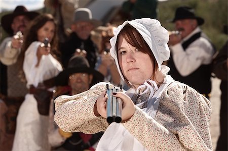 Serious young lady in bonnet pointing a double barrel shotgun Stock Photo - Budget Royalty-Free & Subscription, Code: 400-06136051