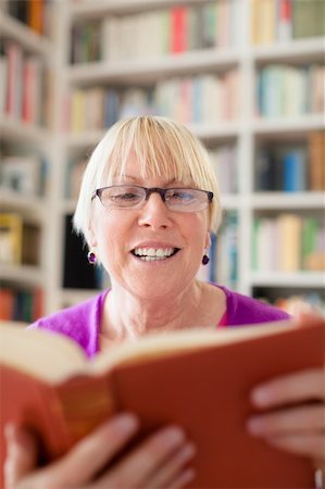 simsearch:400-06106335,k - Portrait of happy retired caucasian woman with eyeglasses reading book at home Stock Photo - Budget Royalty-Free & Subscription, Code: 400-06136132
