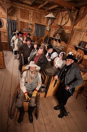 Relaxed customers in old west tavern with weapons at their sides Stock Photo - Budget Royalty-Free & Subscription, Code: 400-06136520