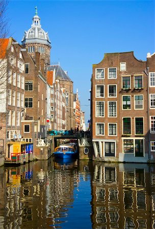 Blue boat on channel in Amsterdam. Typical Amsterdam architecture. Urban space in the spring. Stockbilder - Microstock & Abonnement, Bildnummer: 400-06136548