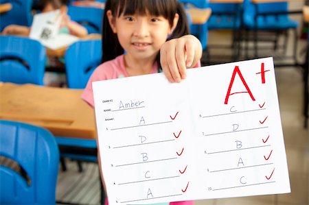 first responder - smiling little girl showing exam paper with a plus in the classroom Photographie de stock - Aubaine LD & Abonnement, Code: 400-06136624