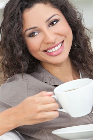 smiling young latina models - Beautiful young Latina Hispanic woman smiling, relaxing and drinking a cup of coffee or tea Foto de stock - Super Valor sin royalties y Suscripción, Código: 400-06136727