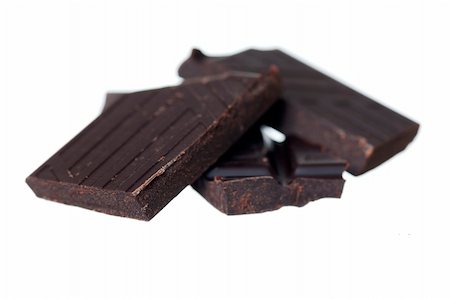 simsearch:400-08789726,k - Pile of dark chocolate chunks on white background. Focus on front left. Photographie de stock - Aubaine LD & Abonnement, Code: 400-06137666