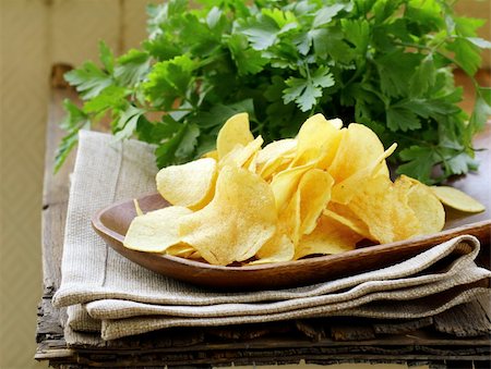 paper thin - potato chips in wooden plate , on a wooden table Foto de stock - Super Valor sin royalties y Suscripción, Código: 400-06137707