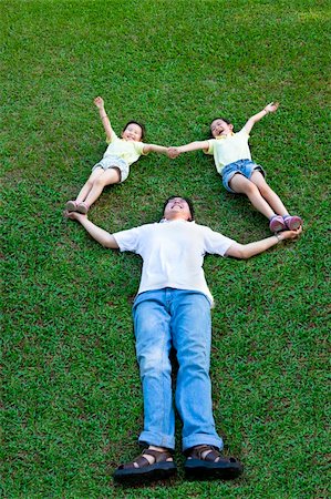 father son lying grass - happy asian family lying and playing on the grass Foto de stock - Super Valor sin royalties y Suscripción, Código: 400-06137750
