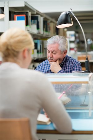 simsearch:400-06107800,k - Elderly man studying among young college students in library and taking notes Photographie de stock - Aubaine LD & Abonnement, Code: 400-06138095