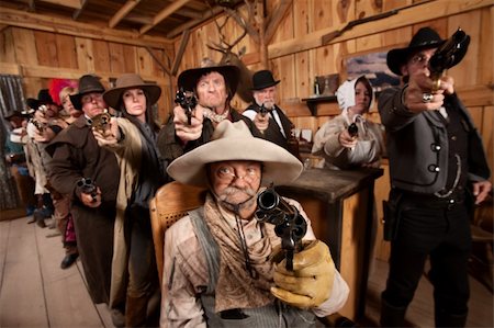 Tough group saloon customers aim their weapons straight ahead. Focus is on gun barrel. Stock Photo - Budget Royalty-Free & Subscription, Code: 400-06138347