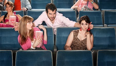 Shocked young women near flirting man in theater Stock Photo - Budget Royalty-Free & Subscription, Code: 400-06138366