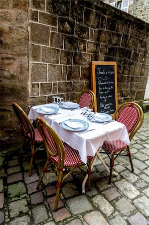 Dining table in front of the french medieval buildings Stockbilder - Microstock & Abonnement, Bildnummer: 400-06138395