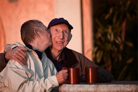 simsearch:400-06139916,k - Senior woman kisses happy man in hat outdoors Stock Photo - Budget Royalty-Free & Subscription, Code: 400-06139916