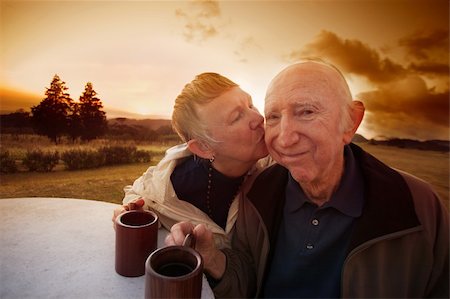 Senior man smirks while lady kisses him outside in field Stock Photo - Budget Royalty-Free & Subscription, Code: 400-06139925