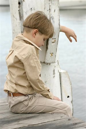 sad pic boy in water - Grieving the loss of a loved one, dog/cat, etc.  Boy hangs head low grieving or lonely Stock Photo - Budget Royalty-Free & Subscription, Code: 400-06130546