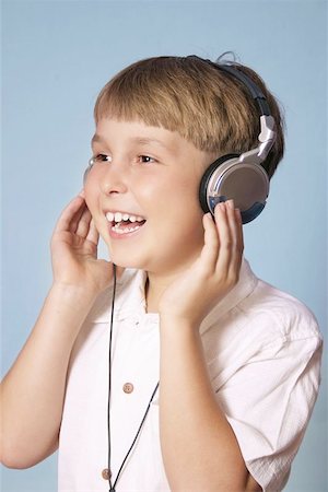 Child listens to music through headphones and smiles.  (shallow dof) Stock Photo - Budget Royalty-Free & Subscription, Code: 400-06130639