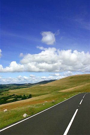 simsearch:400-05927897,k - Rural mountain road in summer, with fields, trees and hills in the distance with a blue sky and cumulus clouds. Set in the Brecon Beacons National Park, Wales, UK. Photographie de stock - Aubaine LD & Abonnement, Code: 400-06130910