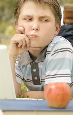 simsearch:400-05078169,k - Boy working on a laptop with an expression of a problem/dilemma.  Could be used for study, schoolwork or homework. Fotografie stock - Microstock e Abbonamento, Codice: 400-06131168