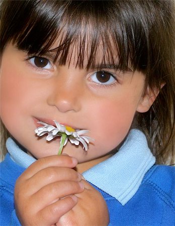 simsearch:400-06131658,k - Face of a little girl with her hands holding a daisy Photographie de stock - Aubaine LD & Abonnement, Code: 400-06131647