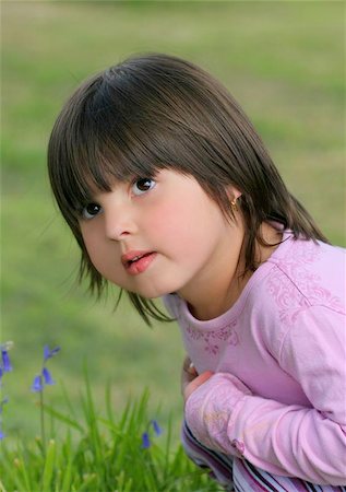 simsearch:400-06131658,k - Face of a little girl sitting on the grass next to some bluebells. Photographie de stock - Aubaine LD & Abonnement, Code: 400-06131708