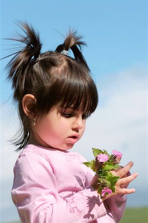 simsearch:400-06131658,k - Little girl with pigtails holding a handful of pink wild flowers. Photographie de stock - Aubaine LD & Abonnement, Code: 400-06131714