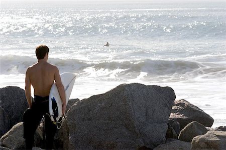 Young man checking out the surf before he gets in. Stock Photo - Budget Royalty-Free & Subscription, Code: 400-06131872