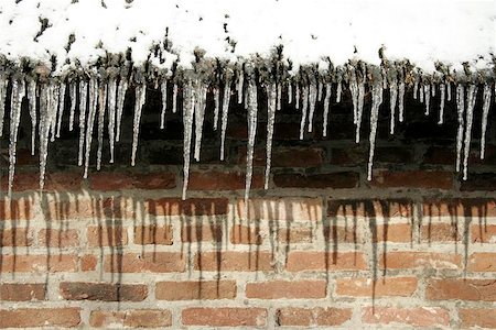 Icicles hanging on roofedge in front of brickwall Stock Photo - Budget Royalty-Free & Subscription, Code: 400-06133618