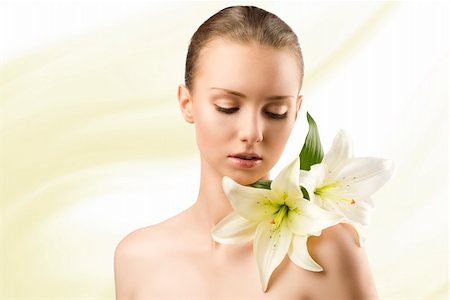 simsearch:400-04323317,k - beauty portait of pretty young girl with lilies, she is slightly turned of three quarters at left and looks lilies on her left shoulder Stock Photo - Budget Royalty-Free & Subscription, Code: 400-06140205