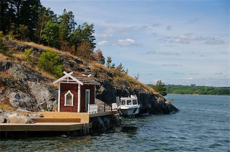 Typical red Swedish cottage and a boat on a small rocky island in the Stockholm archipelago, Baltic Sea, Sweden Foto de stock - Super Valor sin royalties y Suscripción, Código: 400-06140217