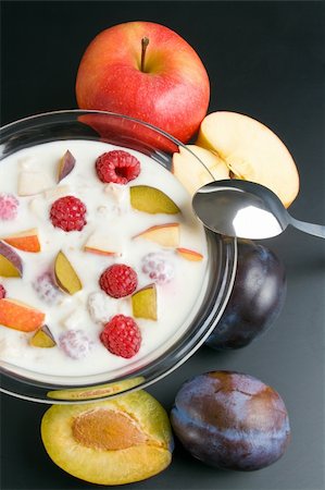 simsearch:400-04922932,k - Glass bowl filled with yogurt mixed with fruit pieces arranged with spoon and some fruits around close-up  isolated on black background. Stock Photo - Budget Royalty-Free & Subscription, Code: 400-06140616