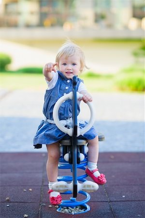 Baby swing on horse on playground and pointing in camera Stock Photo - Budget Royalty-Free & Subscription, Code: 400-06141184