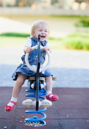 Happy baby swinging on horse on playground Stock Photo - Budget Royalty-Free & Subscription, Code: 400-06141185