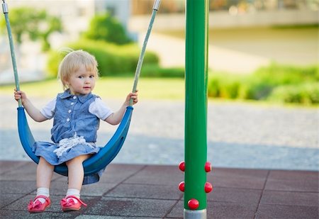 Baby swinging on swing on playground. Side view Stock Photo - Budget Royalty-Free & Subscription, Code: 400-06141187