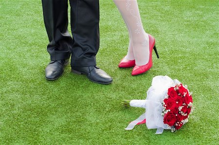 legs of bride and fiance on the green grass with wedding red bouquet Stock Photo - Budget Royalty-Free & Subscription, Code: 400-06142006