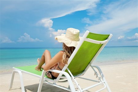 paradise beach girls photos - Young woman with hat relaxing on a deck chair Stock Photo - Budget Royalty-Free & Subscription, Code: 400-06142041