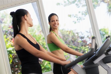 simsearch:400-07554888,k - Young women talking and laughing while working out on exercise  bicycles in wellness club Foto de stock - Super Valor sin royalties y Suscripción, Código: 400-06142459