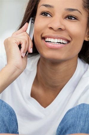 A beautiful young happy African American young woman or girl with a wonderful smile chatting on her cell phone. Stock Photo - Budget Royalty-Free & Subscription, Code: 400-06142733