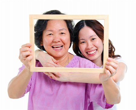 family portraits in frames - Mixed race Asian senior mother and adult daughter looking fun through an empty frame Stock Photo - Budget Royalty-Free & Subscription, Code: 400-06142855