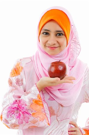 simsearch:400-06142860,k - Young Muslim woman holding an apple on palm, healthy eating concept Fotografie stock - Microstock e Abbonamento, Codice: 400-06142865