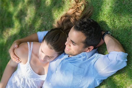 simsearch:400-04399991,k - Happy beautiful young man and woman in love, lying on grass in park and relaxing Photographie de stock - Aubaine LD & Abonnement, Code: 400-06143207