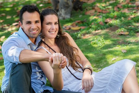 simsearch:400-04399991,k - Happy beautiful young man and woman in love, lying on grass in park and relaxing Photographie de stock - Aubaine LD & Abonnement, Code: 400-06143208