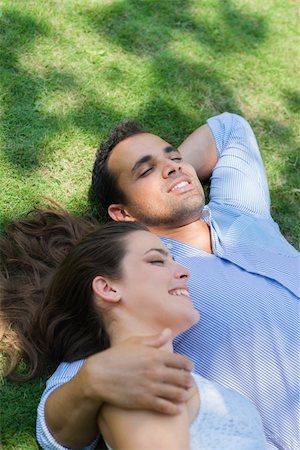 simsearch:400-04399991,k - Happy beautiful young man and woman in love, lying on grass in park and relaxing Photographie de stock - Aubaine LD & Abonnement, Code: 400-06143274