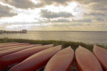 red canoe on lake - Canoes staged on river shore Stock Photo - Budget Royalty-Free & Subscription, Code: 400-06143889