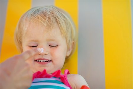 simsearch:400-07426054,k - Mother's hand applying sun block creme on baby nose Photographie de stock - Aubaine LD & Abonnement, Code: 400-06174303