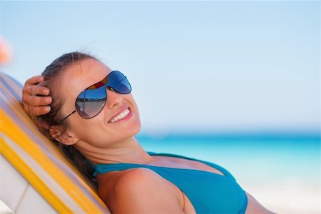 simsearch:400-06174351,k - Smiling woman laying on beach Foto de stock - Super Valor sin royalties y Suscripción, Código: 400-06174344