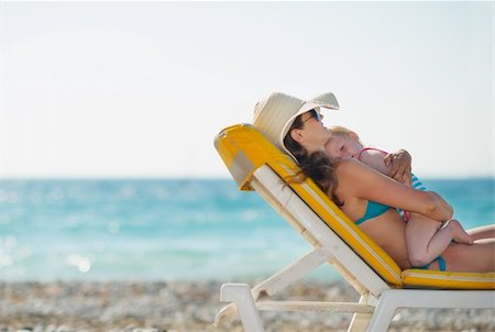 simsearch:400-06174351,k - Mother with baby laying on sunbed on beach Foto de stock - Super Valor sin royalties y Suscripción, Código: 400-06174341