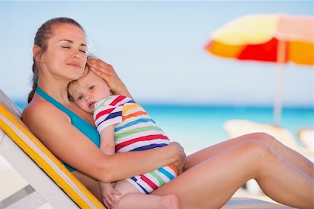simsearch:400-06207710,k - Relaxed mother on sun bed embracing baby Foto de stock - Super Valor sin royalties y Suscripción, Código: 400-06174352