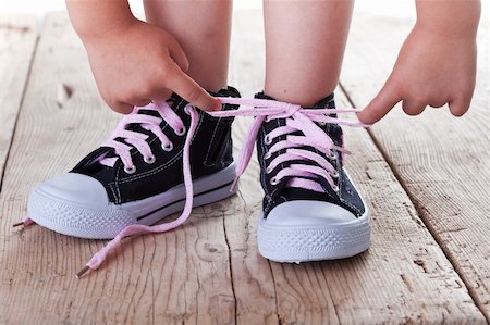 Child successfully ties shoes - closeup on feet and hands Photographie de stock - Aubaine LD & Abonnement, Code: 400-06174640