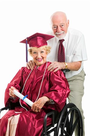 disabled female student - Senior woman in wheelchair graduates with the help of her supportive husband.  Isolated on white. Stock Photo - Budget Royalty-Free & Subscription, Code: 400-06175121