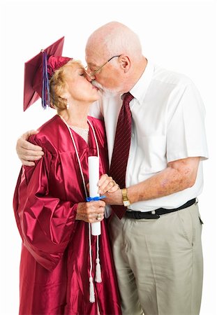 Senior woman gets a kiss from her husband on her graduation day.  Isolated on white. Stock Photo - Budget Royalty-Free & Subscription, Code: 400-06175132
