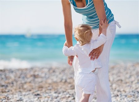 Baby on beach climbing mothers hands Stock Photo - Budget Royalty-Free & Subscription, Code: 400-06175326