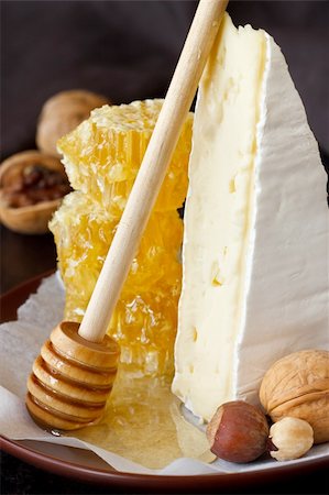Delicious cheese, nuts and honeycombs on a ceramic plate. Photographie de stock - Aubaine LD & Abonnement, Code: 400-06175347